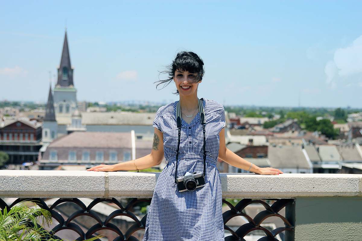 human woman wearing blue dress standing beside stand spire