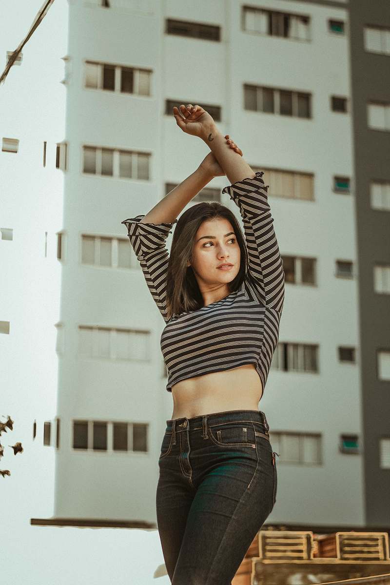 person woman wearing gray and black striped long-sleeve shirt holding her wrist human