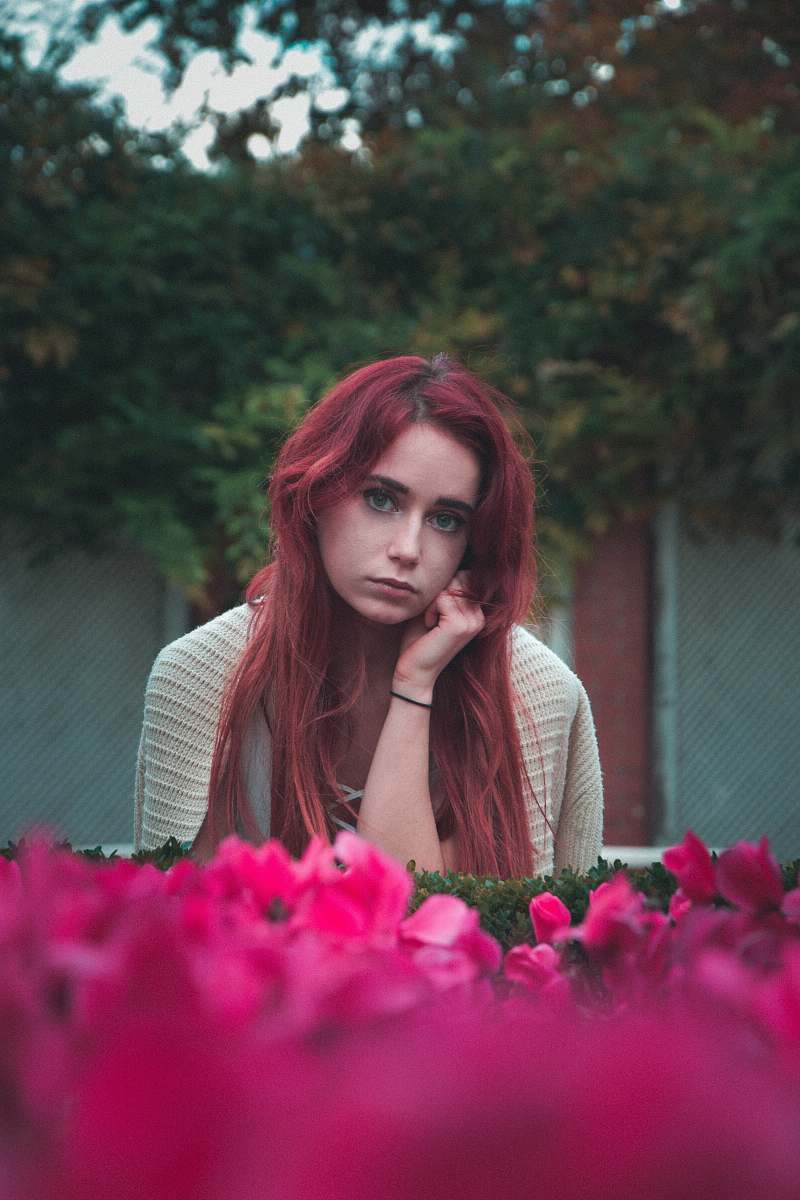 human woman wearing grey shirt near pink petaled flowers during daytime person