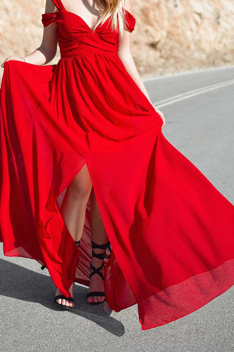human woman wearing red cold-shoulder front-slit formal dress standing on road person