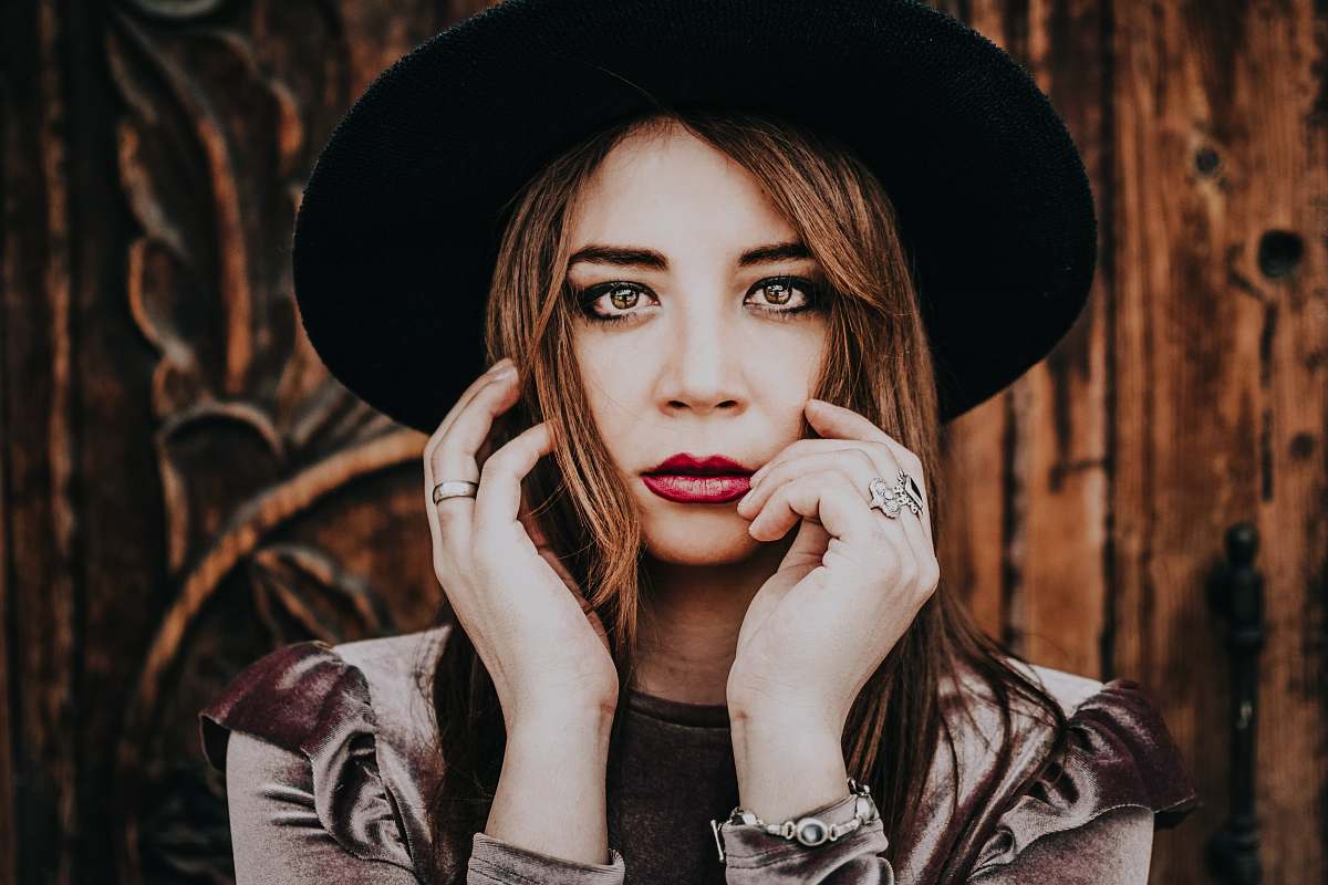 human woman wearing sunhat posing near wall person