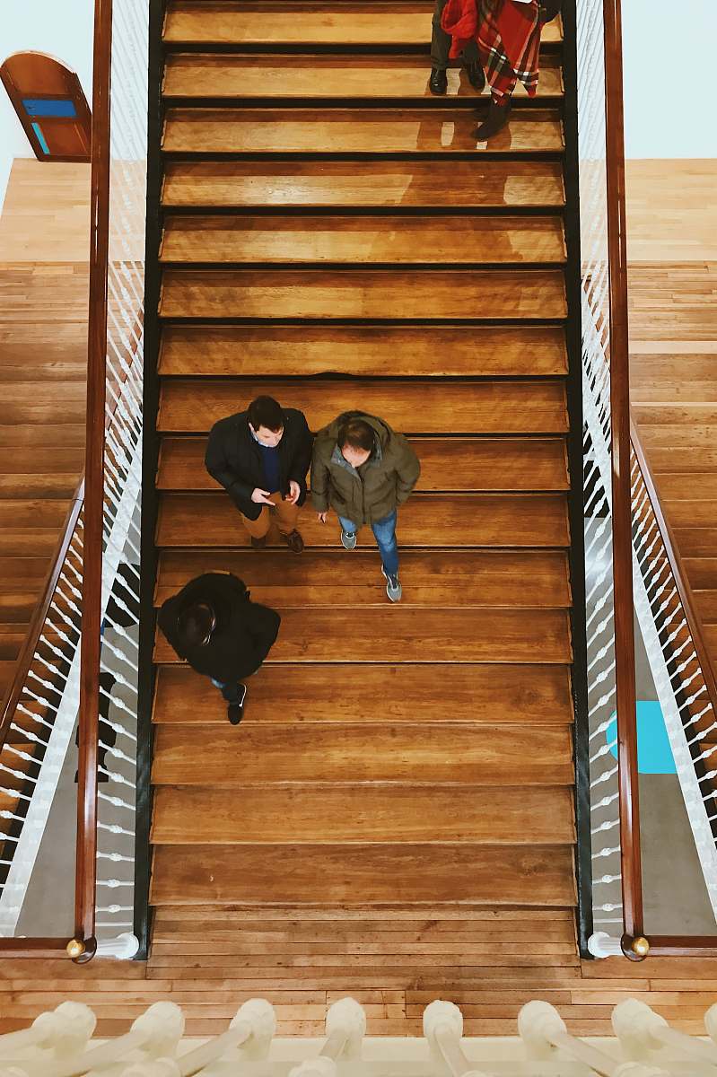 people aerial photography of person walking on stair human