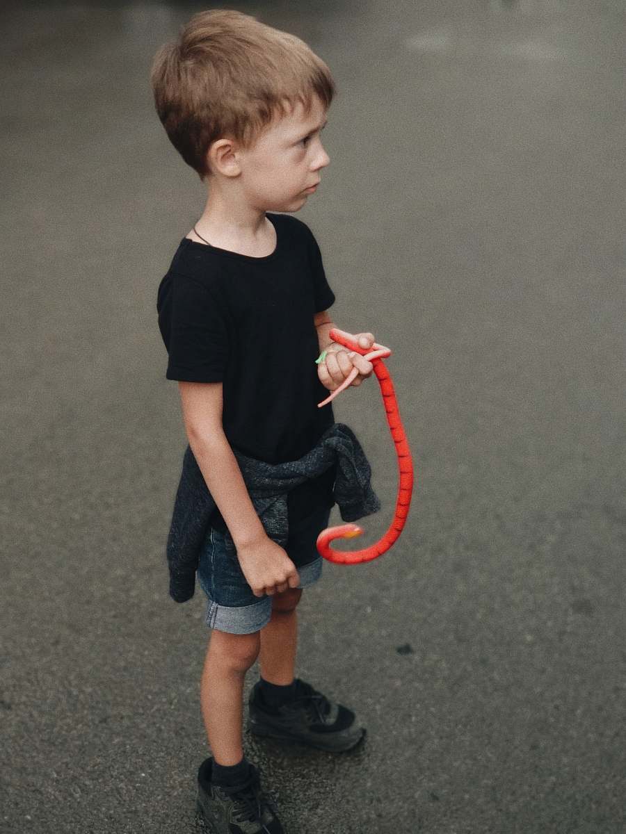 human boy holding red snake toy people