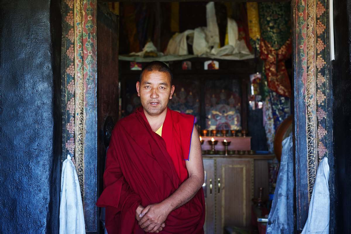 people buddhist monk standing behind brown wooden cabinet human