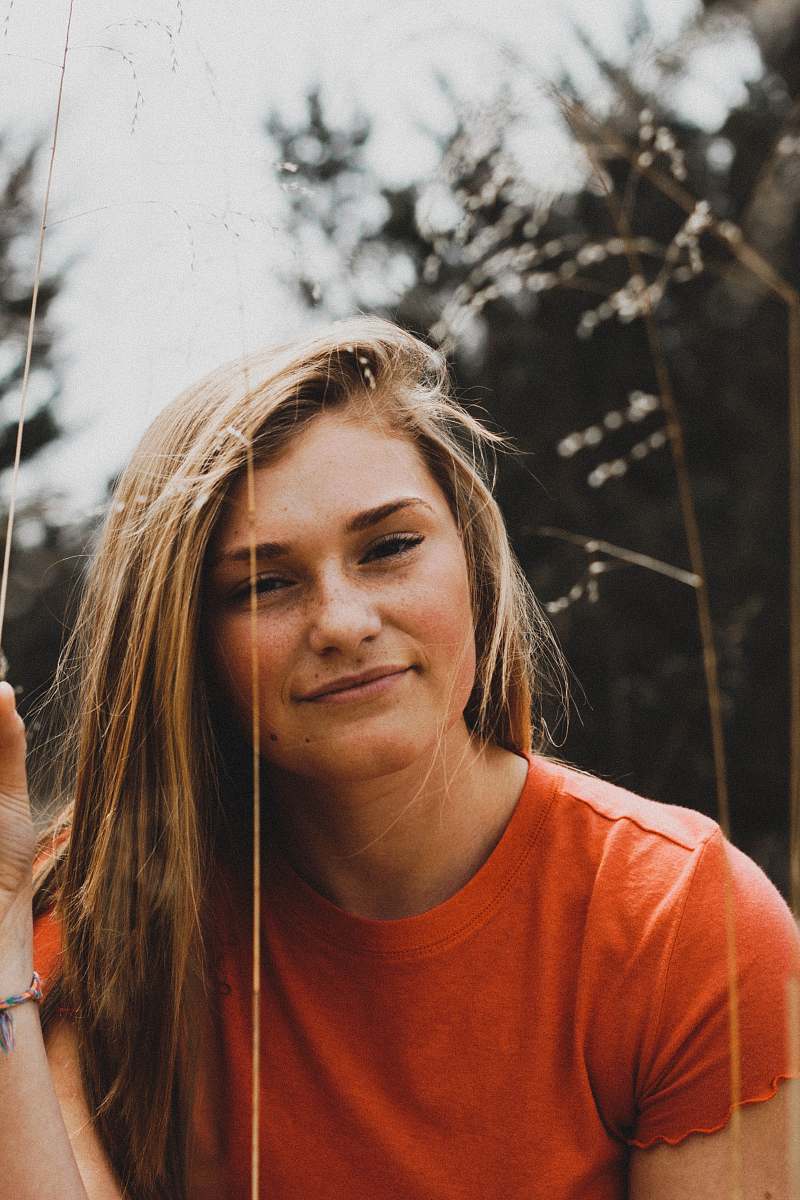 human close-up photo of woman in orange crew-neck shirt people