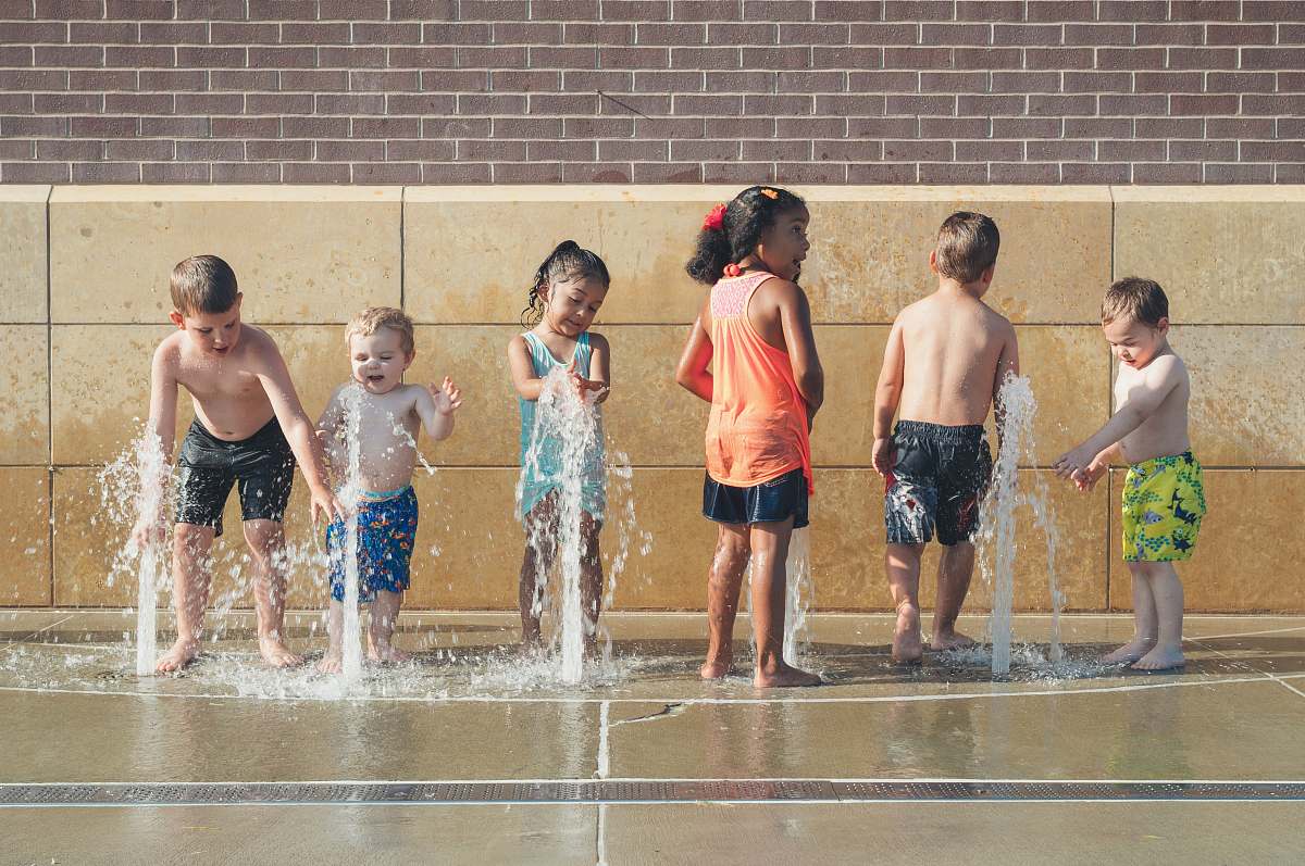 human five children playing water during day time people