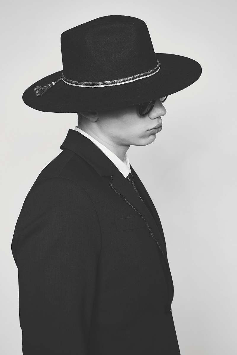 black-and-white grayscale photo of person's blazer hat