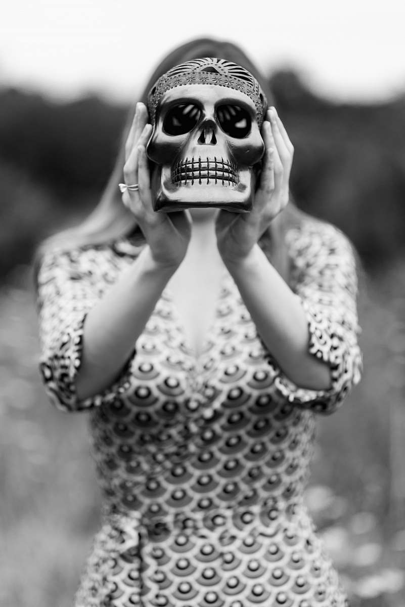 people grayscale photography of woman holding skull figurine black-and-white
