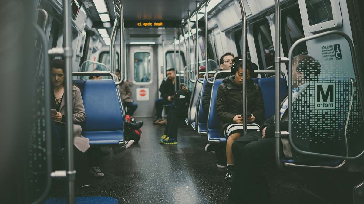 subway group of person sitting on blue chairs train