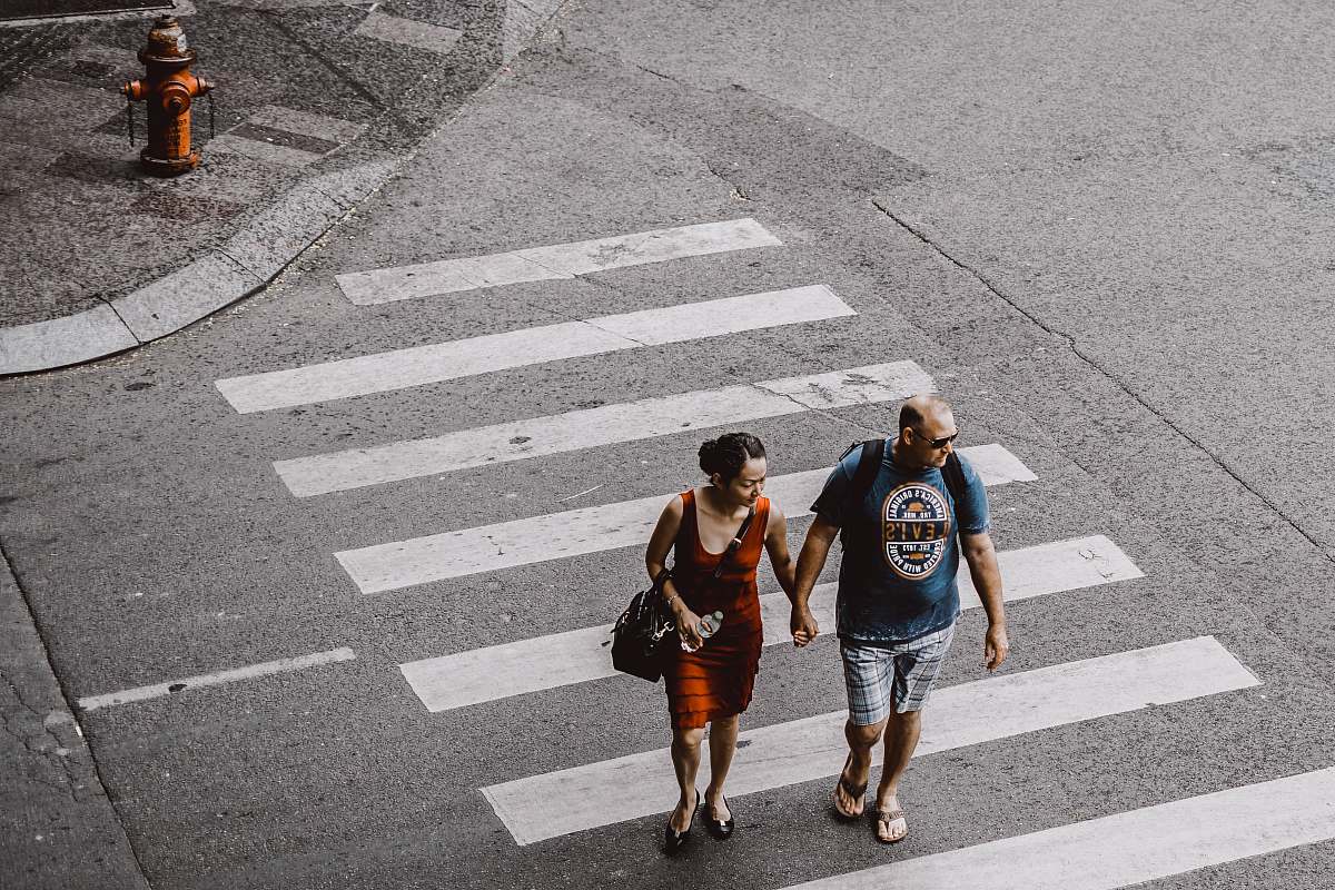 human man and woman walking on pedestrian lane during daytime people