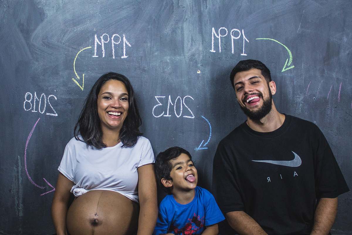 human man, boy, and girl standing under chalkboard people