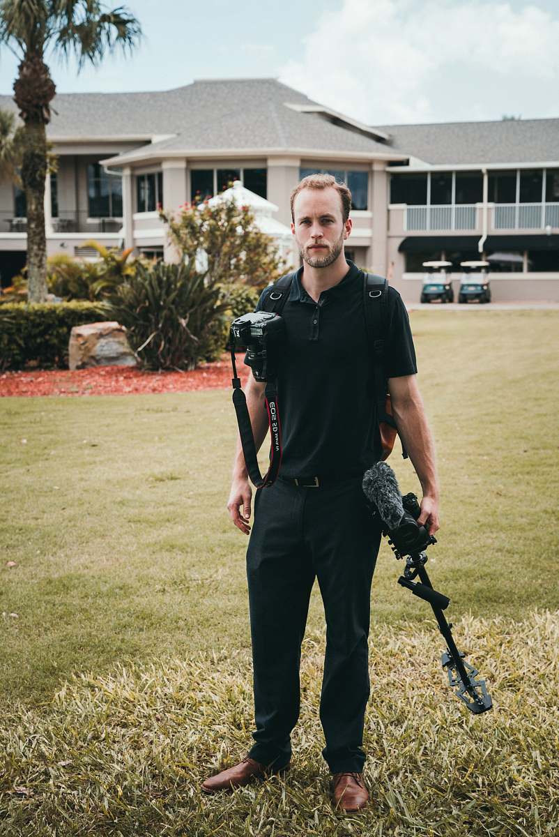 people man holding black glide cam and black Canon DSLR camera human
