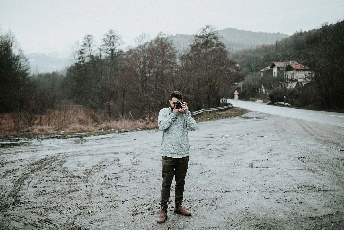 photographer man holding camera in snow-covered road people