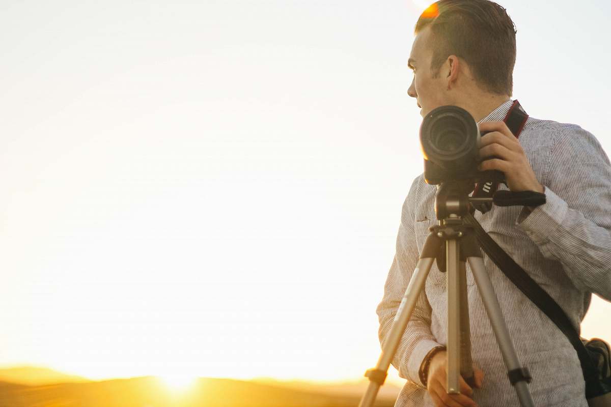 people man holding DSLR camera during golden hour human