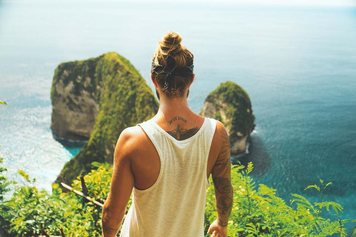 people man in white tank top facing near the cliff human