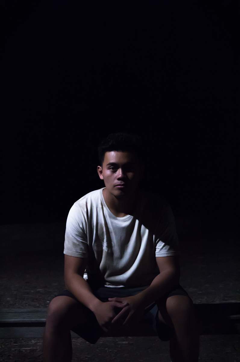 human man sitting on ground with black background people