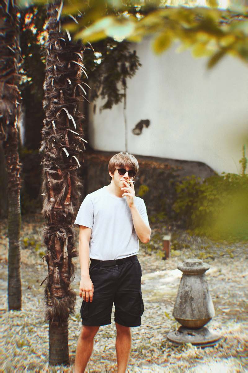 people man smoking cigarette walking beside tree human