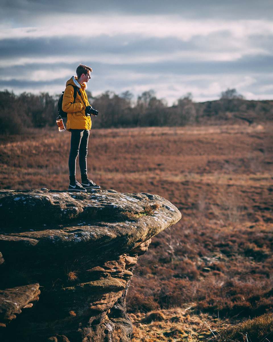 people man standing at cliff holding his camera human