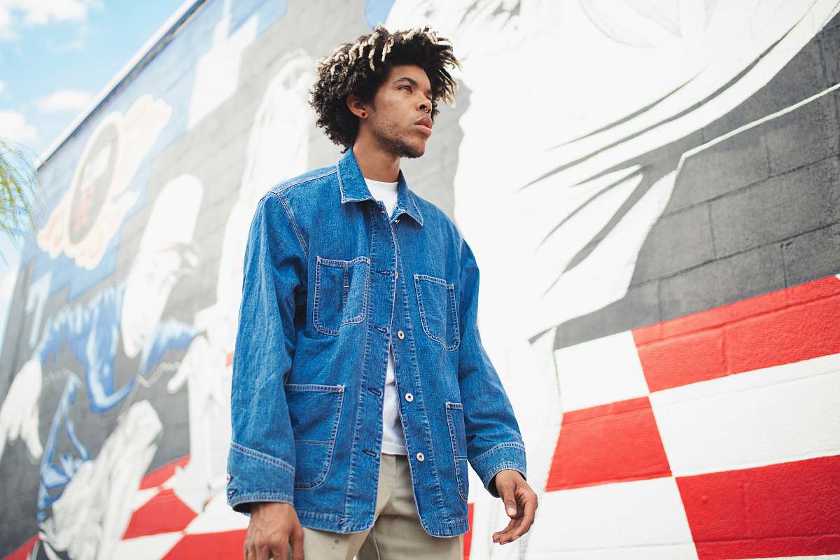 human man standing beside black, red, and white painted wall during daytime people
