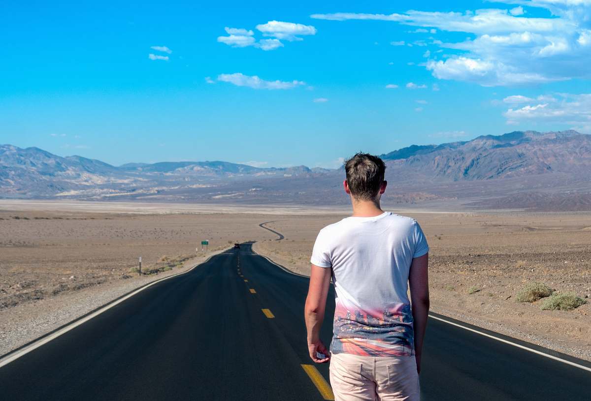 human man standing in the middle of the road people