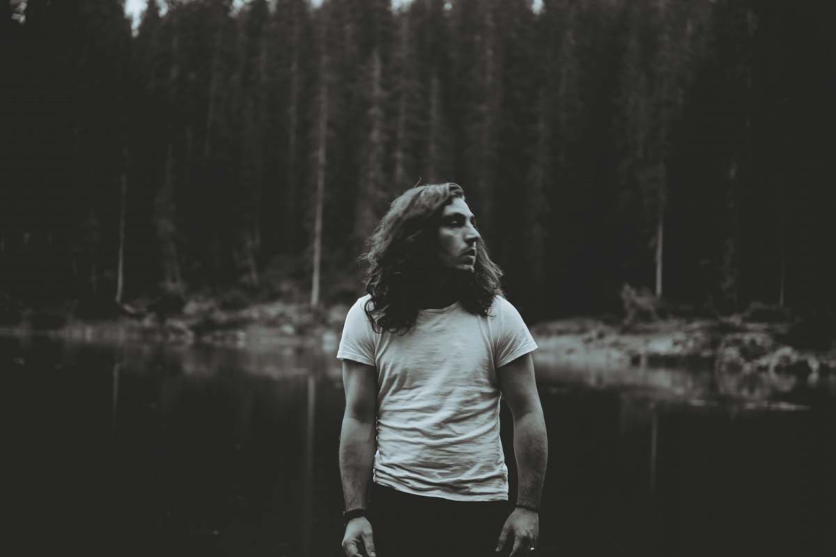 people man standing near body of water grey