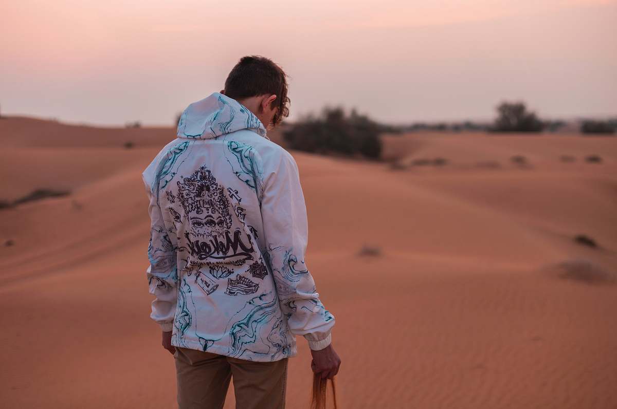 human man standing on desert holding sand during daytime people