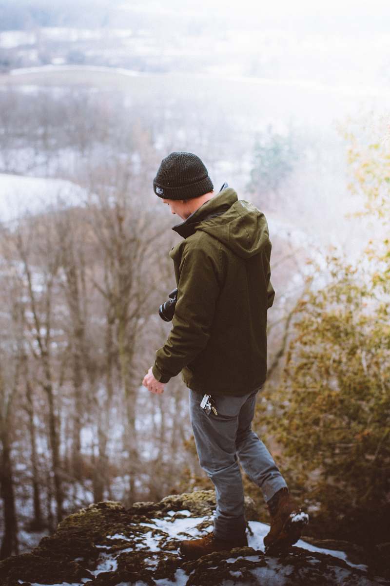human man standing on gray rock formation people