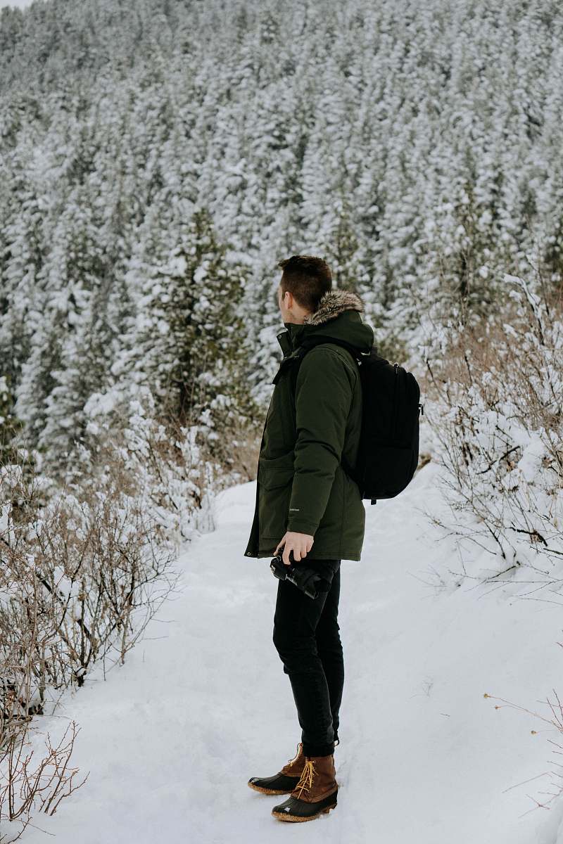 people man standing on snow looking on trees during daytime human