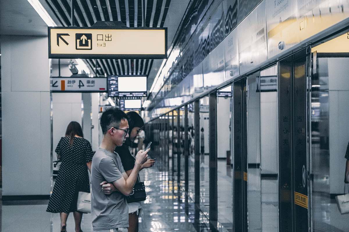 human man standing under brown and black signage people