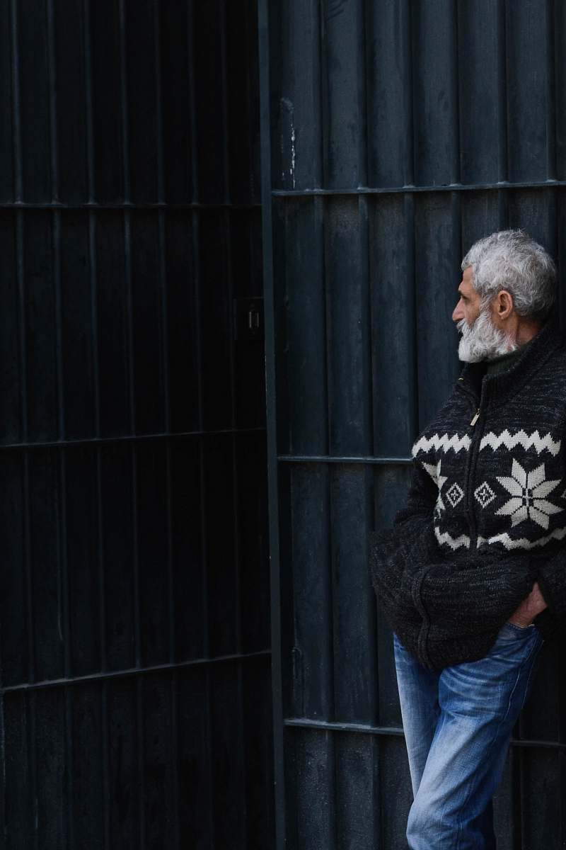human man standing while leaning on black gate people