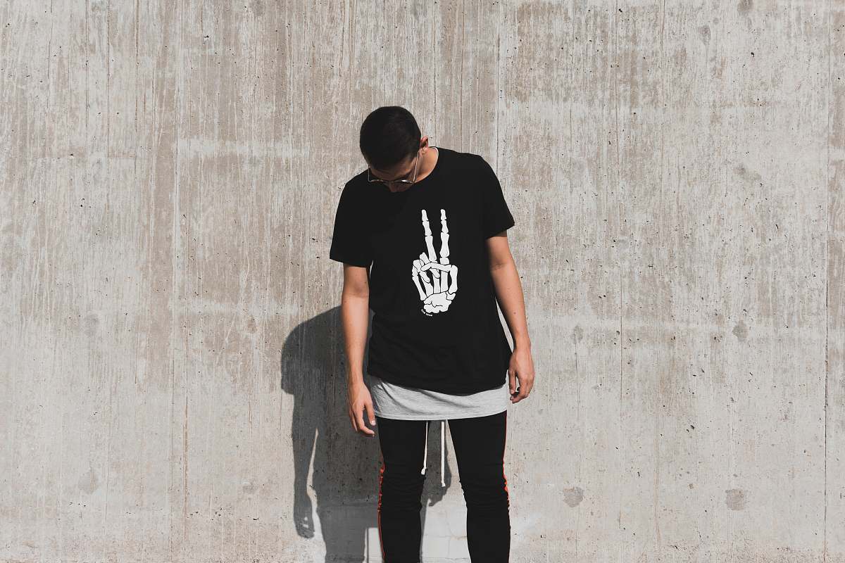 people man standing while looking down at daytime shirt