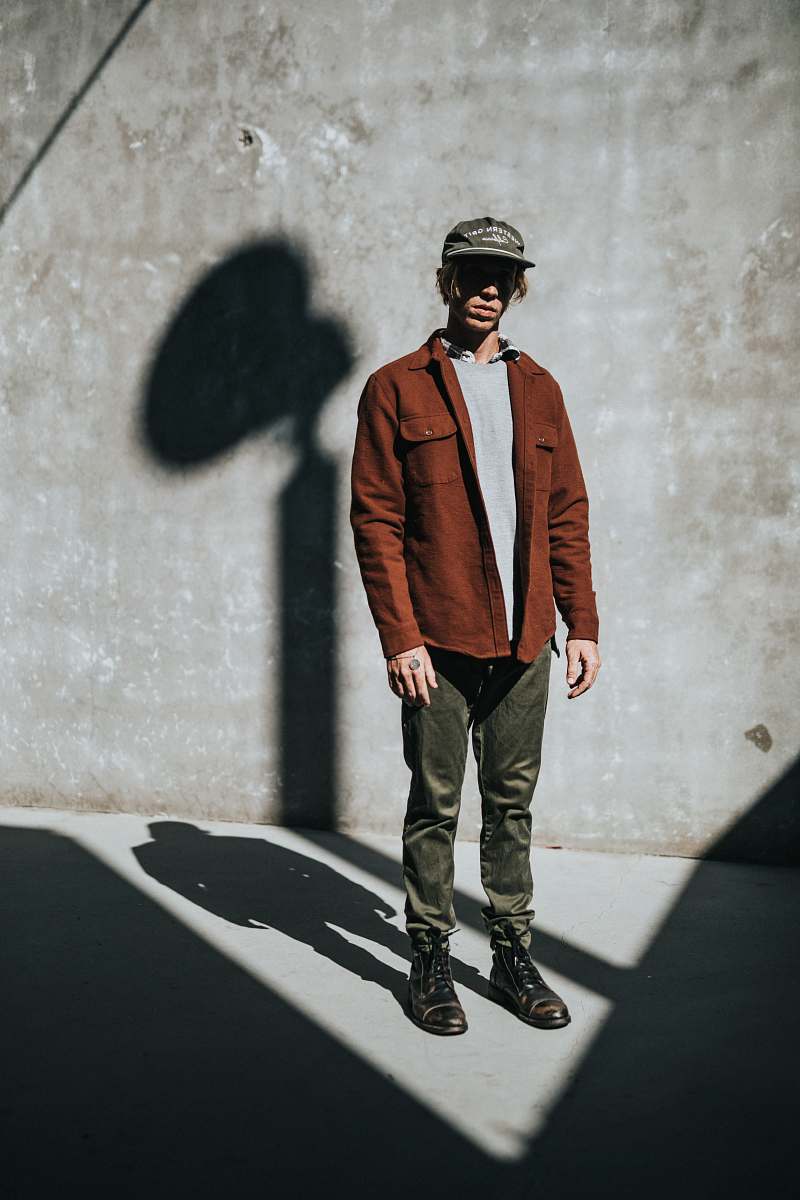 human man stands near concrete wall with shadow people