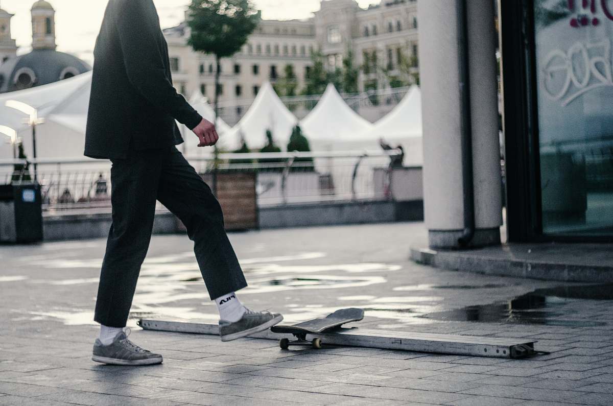human man stepping on skateboard people