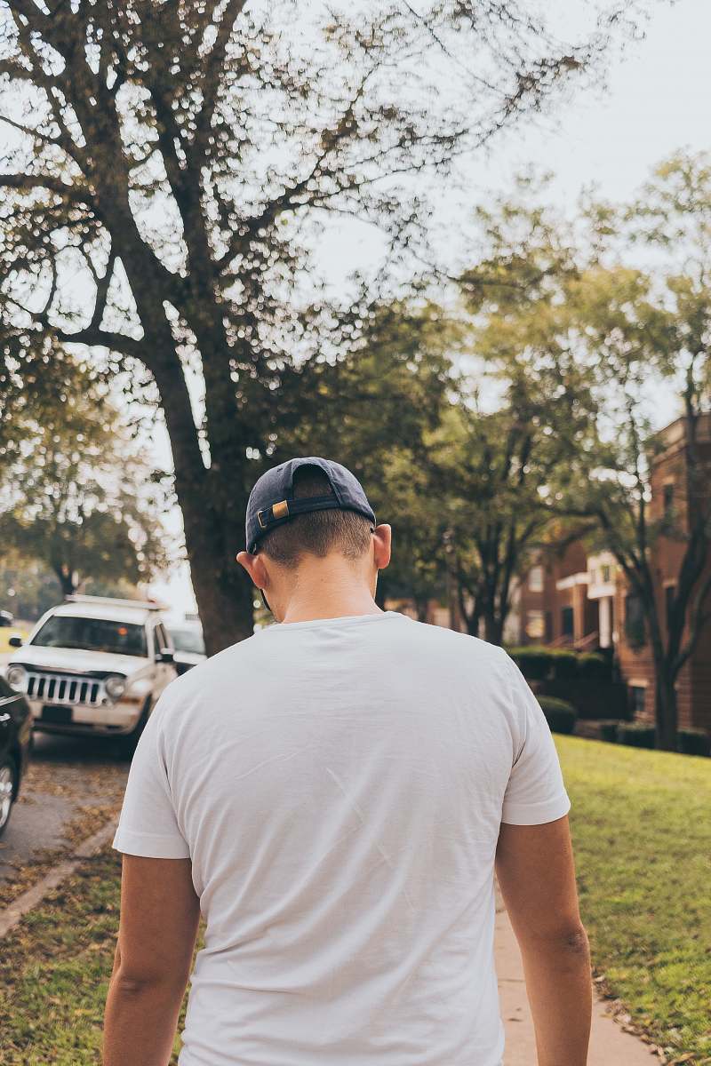 Capture the essence of urban life with this dynamic image of a man confidently walking down the street, sporting a trendy cap. Perfect for lifestyle blogs, travel articles, or marketing campaigns focused on fashion and city living, this photograph encapsulates the spirit of exploration and individuality in a bustling environment. The scene is set against a vibrant backdrop, making it ideal for diverse creative projects.