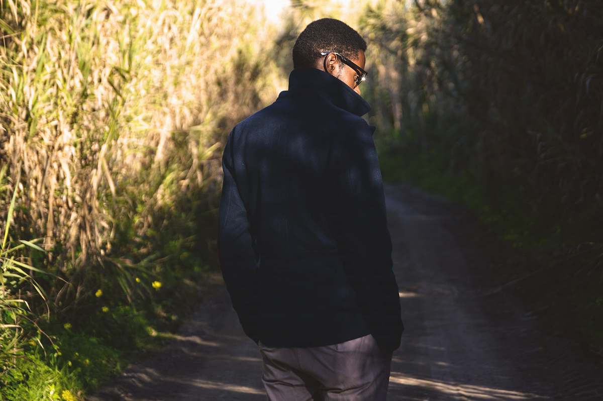 human man walking near green leafed plants people