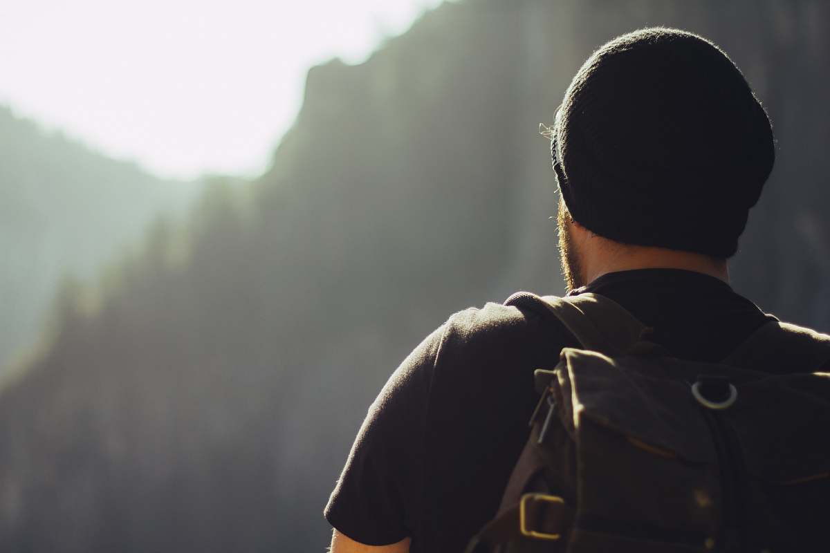 people man wearing black t-shirt and knit cap fronting mountains man