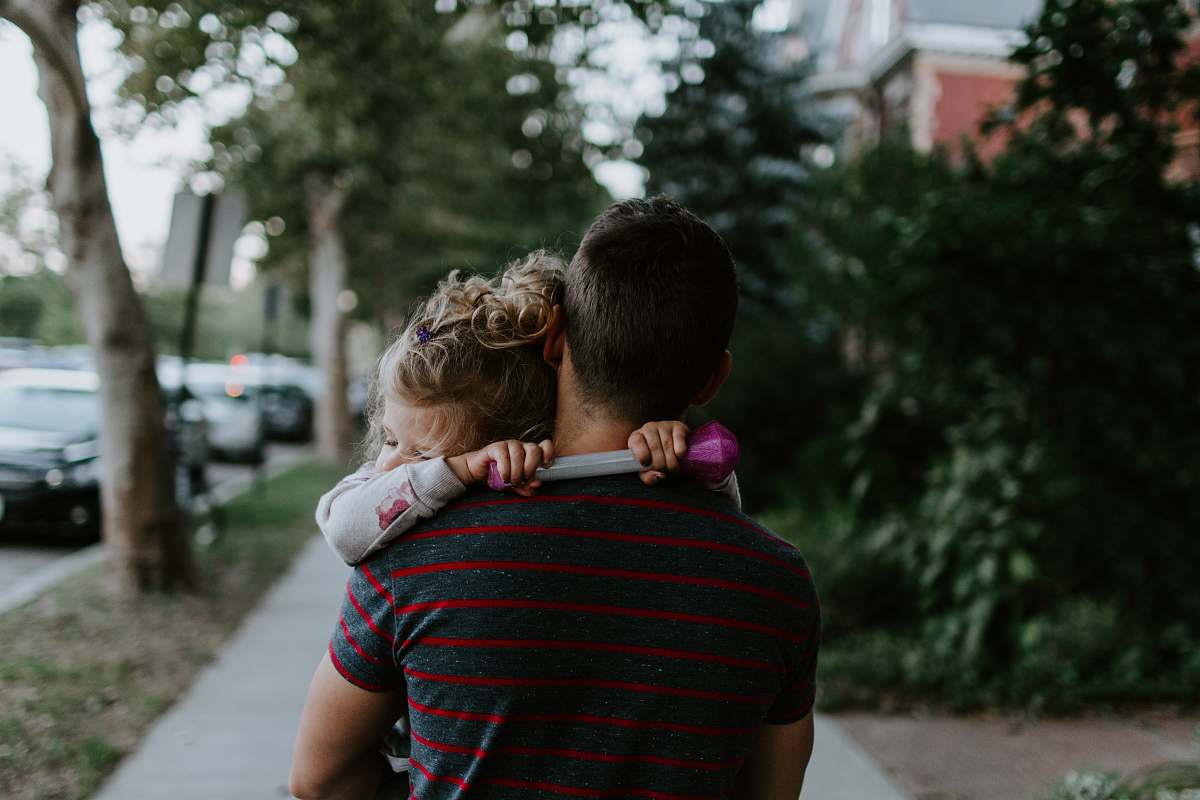 human man wearing gray and purple striped crew-neck shirt carrying toddlers people