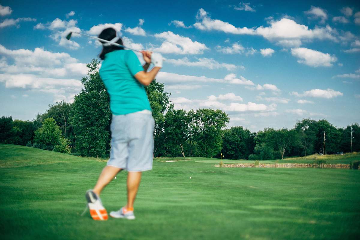 sport man with swung golf club at the field during day golf