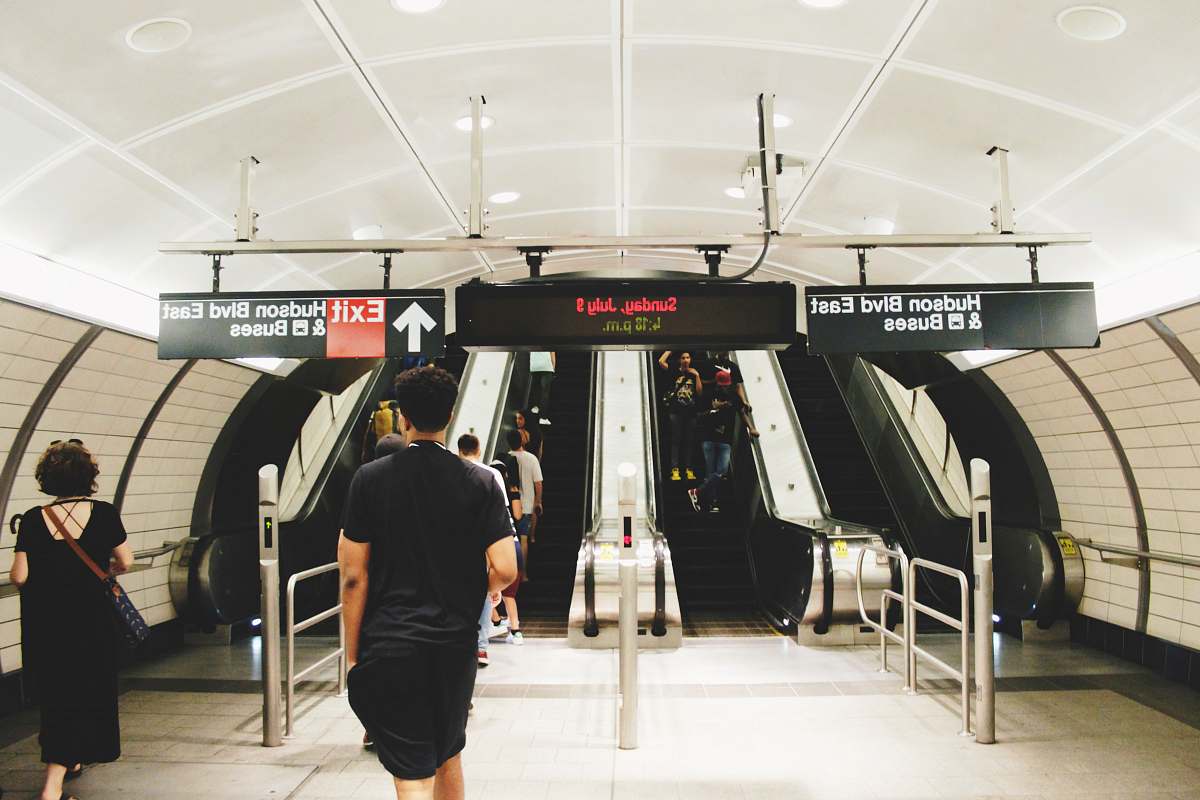 people people walking towards escalator inside Bus station human
