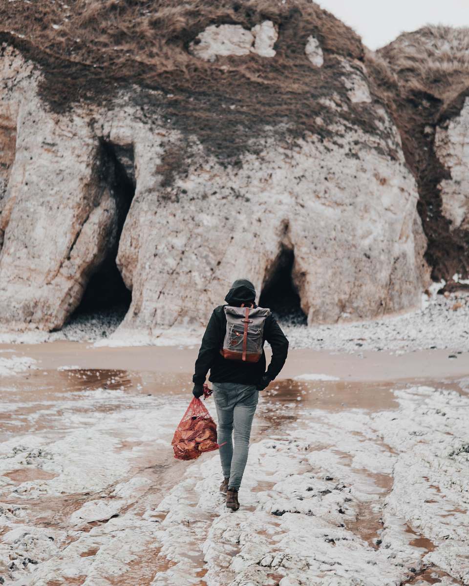 people person black shirt with backpack walking on seashore human