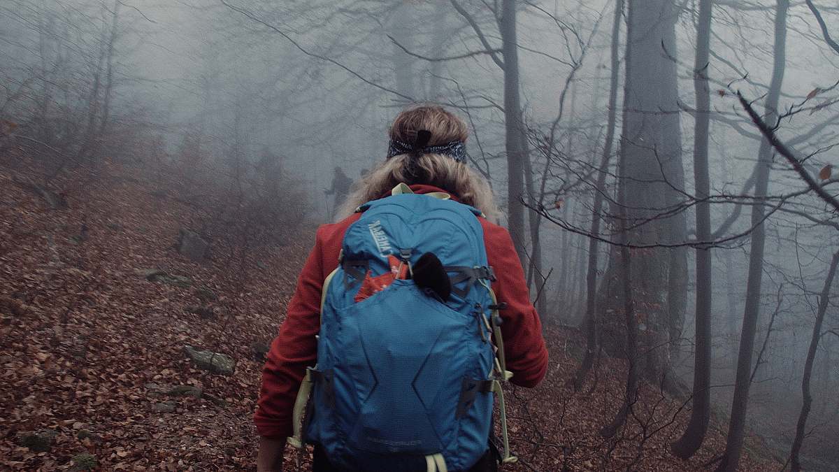 human person carrying blue rucksack backpack on wod people