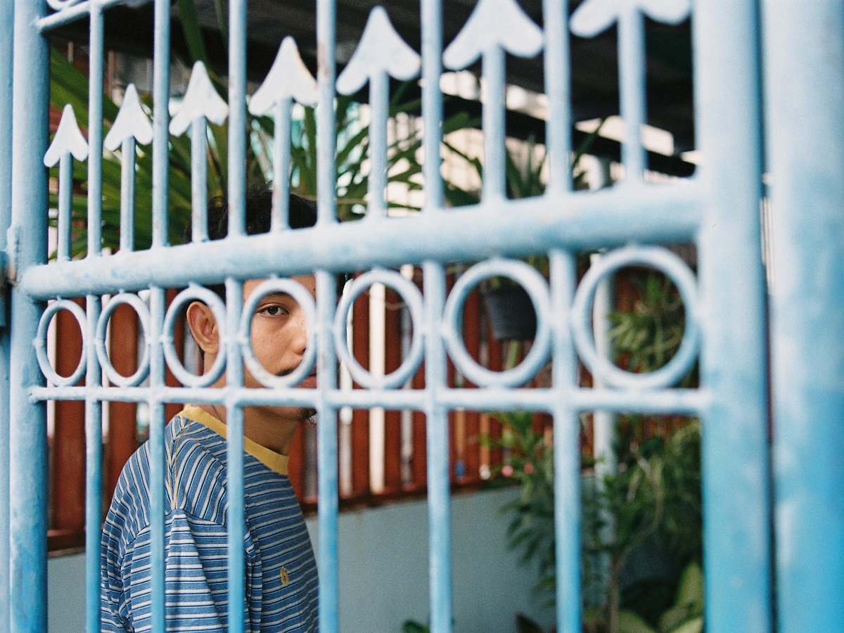 people person inside structure blocked by gray gate human