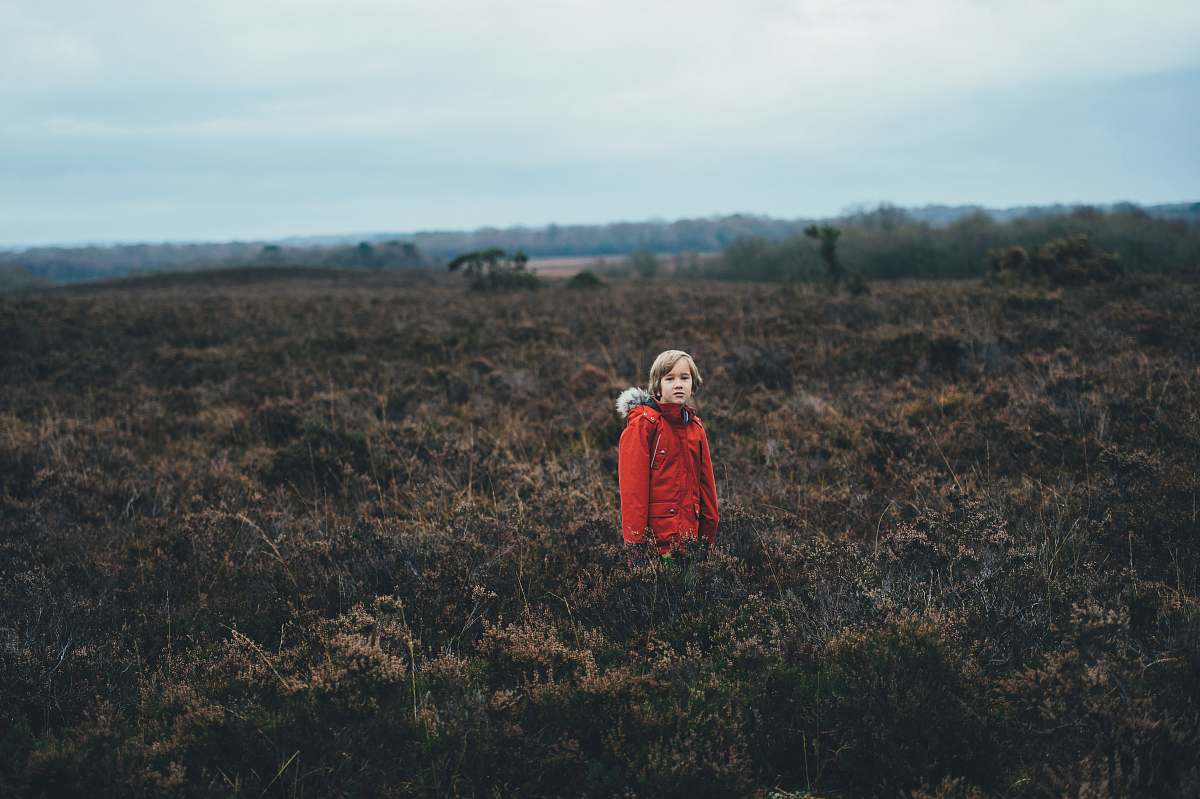 human person standing in the middle of green plants people