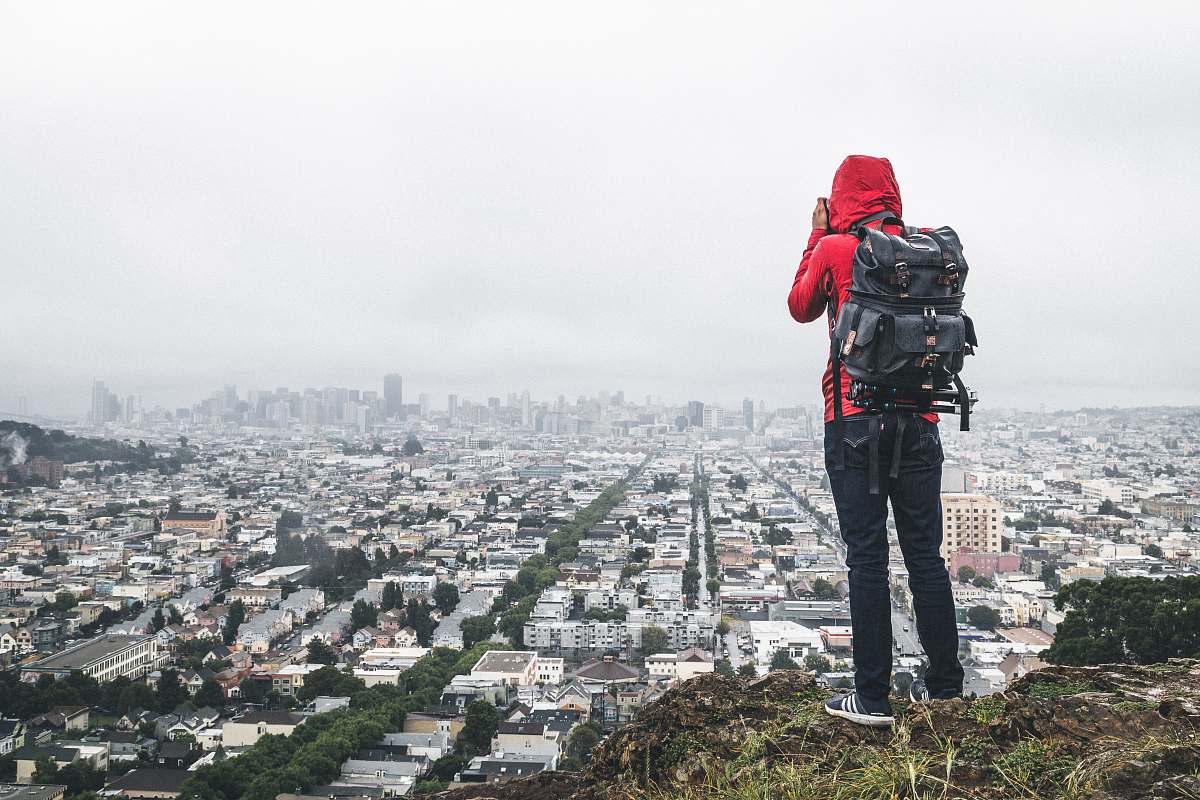 photographer person standing on cliff over city male
