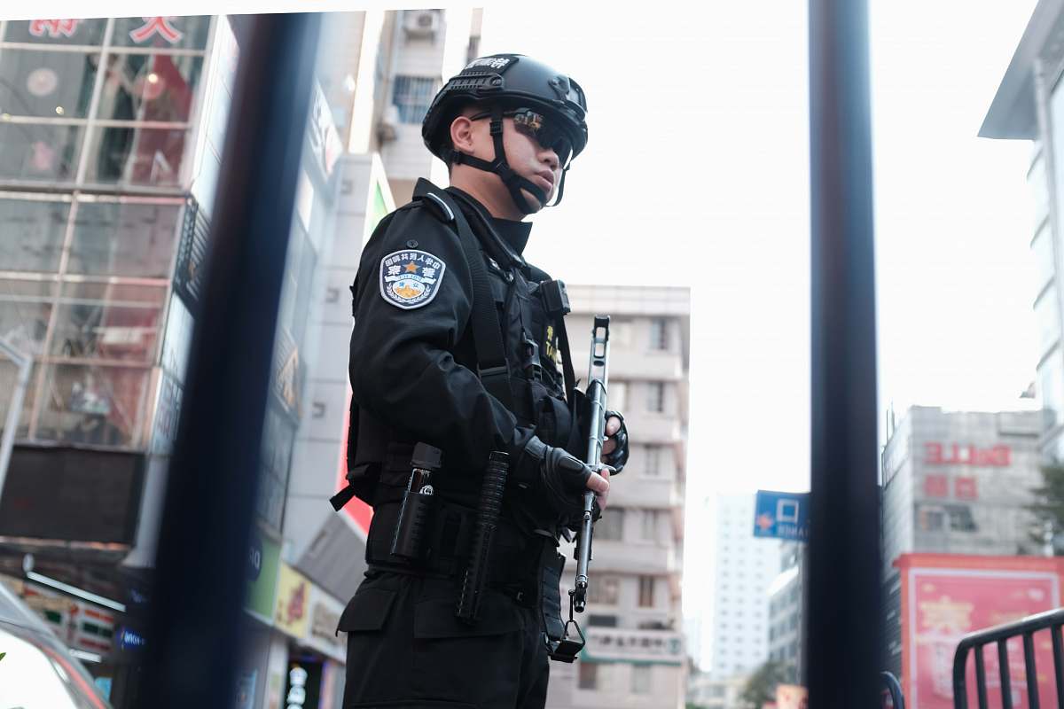 human police holding rifle while standing people