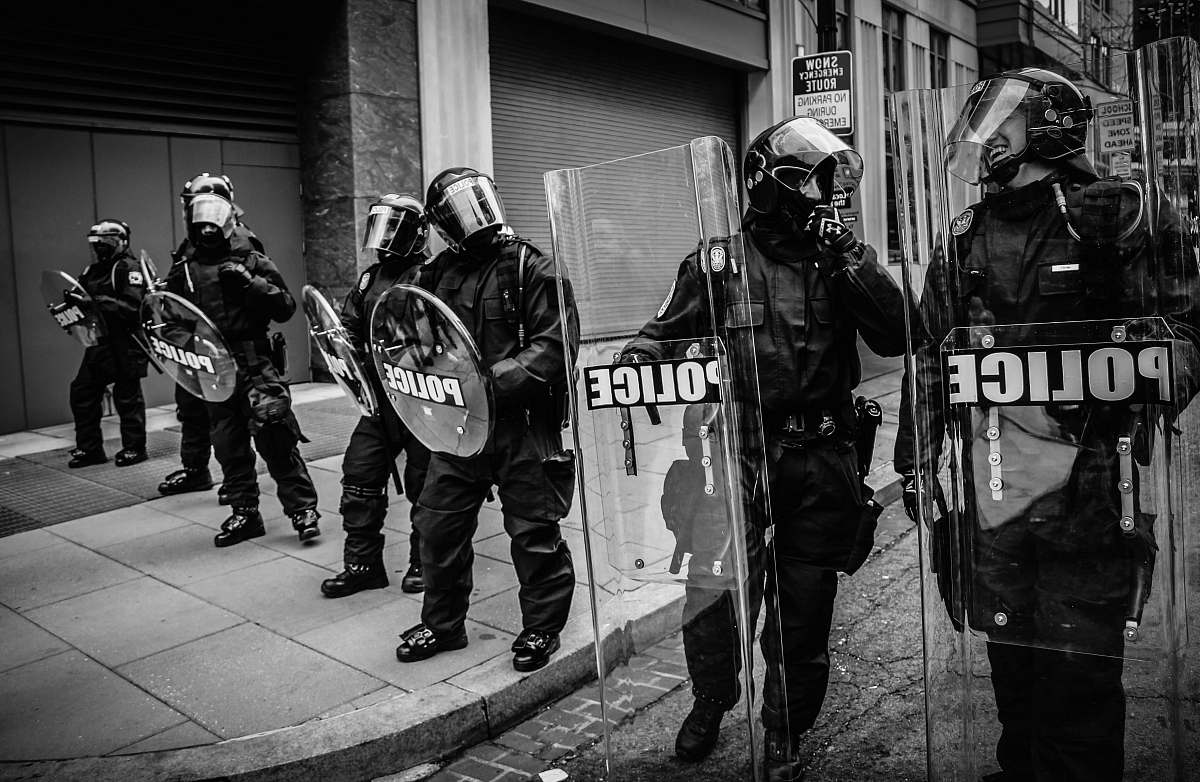 people policemen holding clear fiber glass shield black-and-white