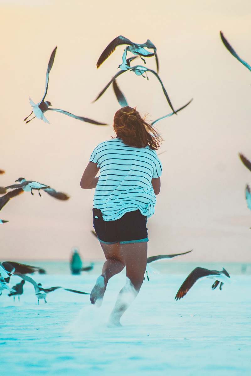 people running woman surrounded by birds at daytime human