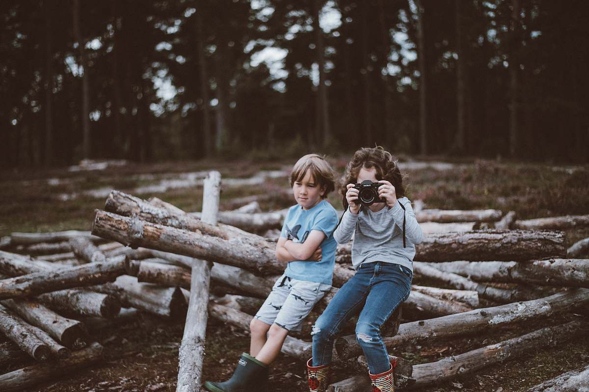 human selective focus photography of boy and girl sitting on log people