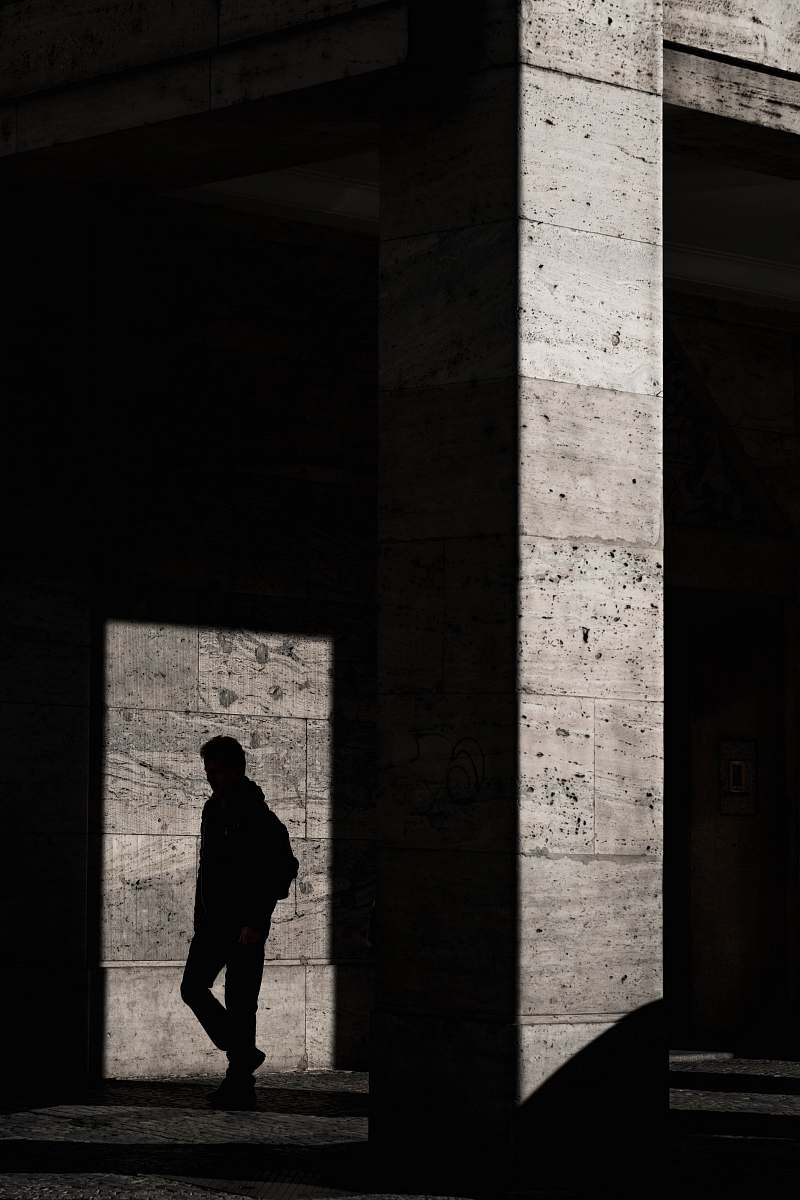 This captivating image features the silhouette of a man standing inside a modern architectural structure, embodying the interplay of light and shadow. The intriguing contrast creates a dramatic atmosphere, making it perfect for themes like solitude, urban exploration, and architectural design. Ideal for use in articles, marketing materials, or creative projects that emphasize the relationship between humanity and built environments.
