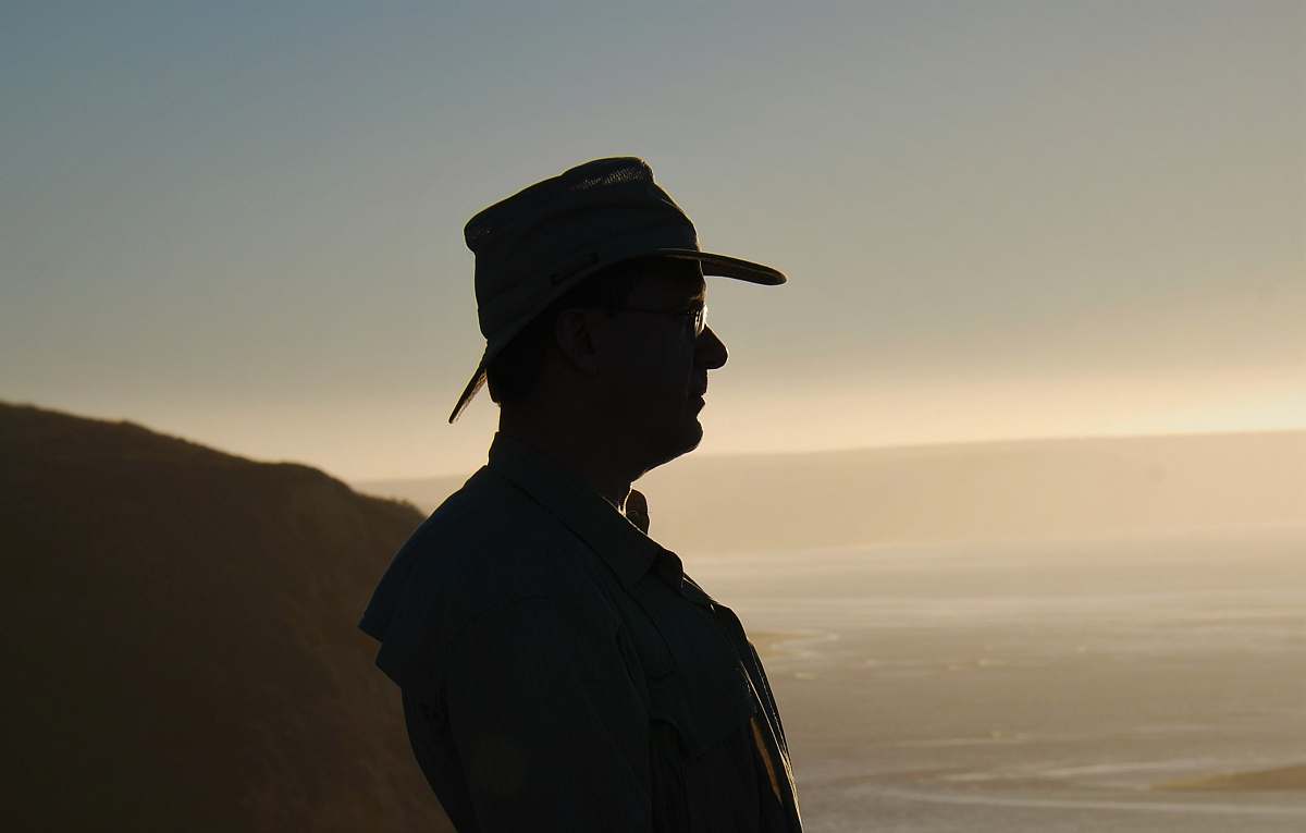 people silhouette of man standing near body of water human